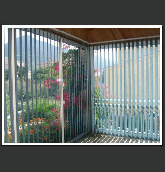 Store &agrave; bandes verticales 
dans une v&eacute;randa